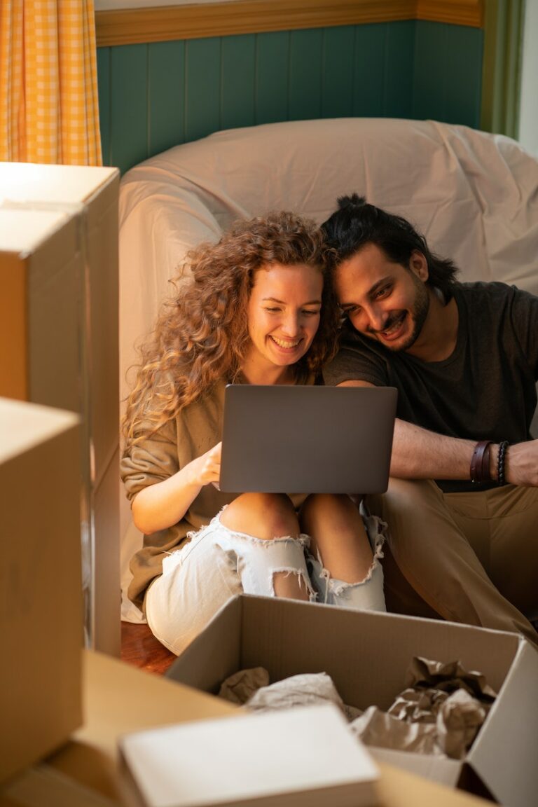Couple heureux utilisant un ordinateur portable dans un appartement